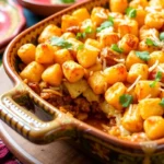 Taco tater tot casserole topped with crispy tater tots and melted cheese.